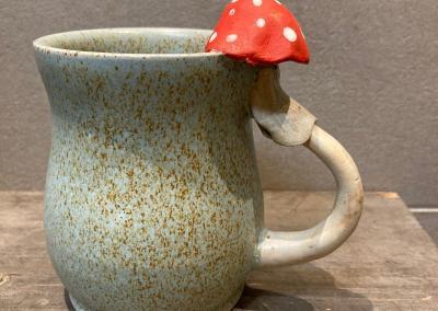 Tasse beige avec champignon chapeau rouge points blanc sur le haut de l'ance